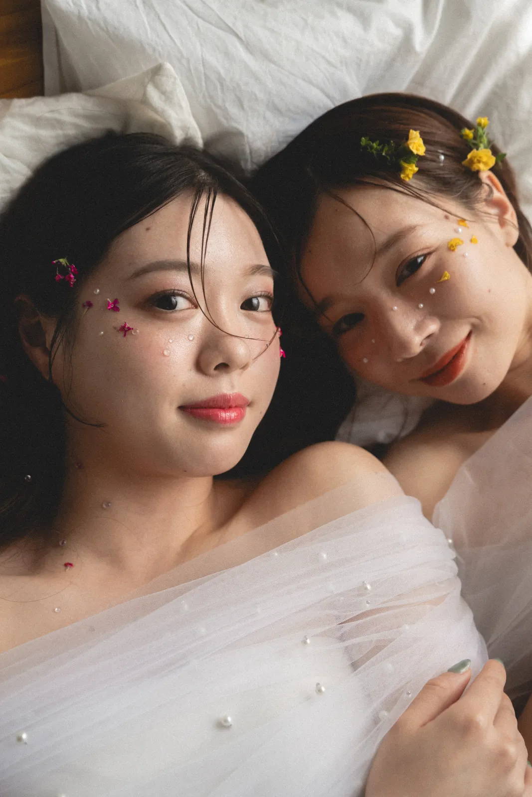 白い布に横たわる2人のポートレート
